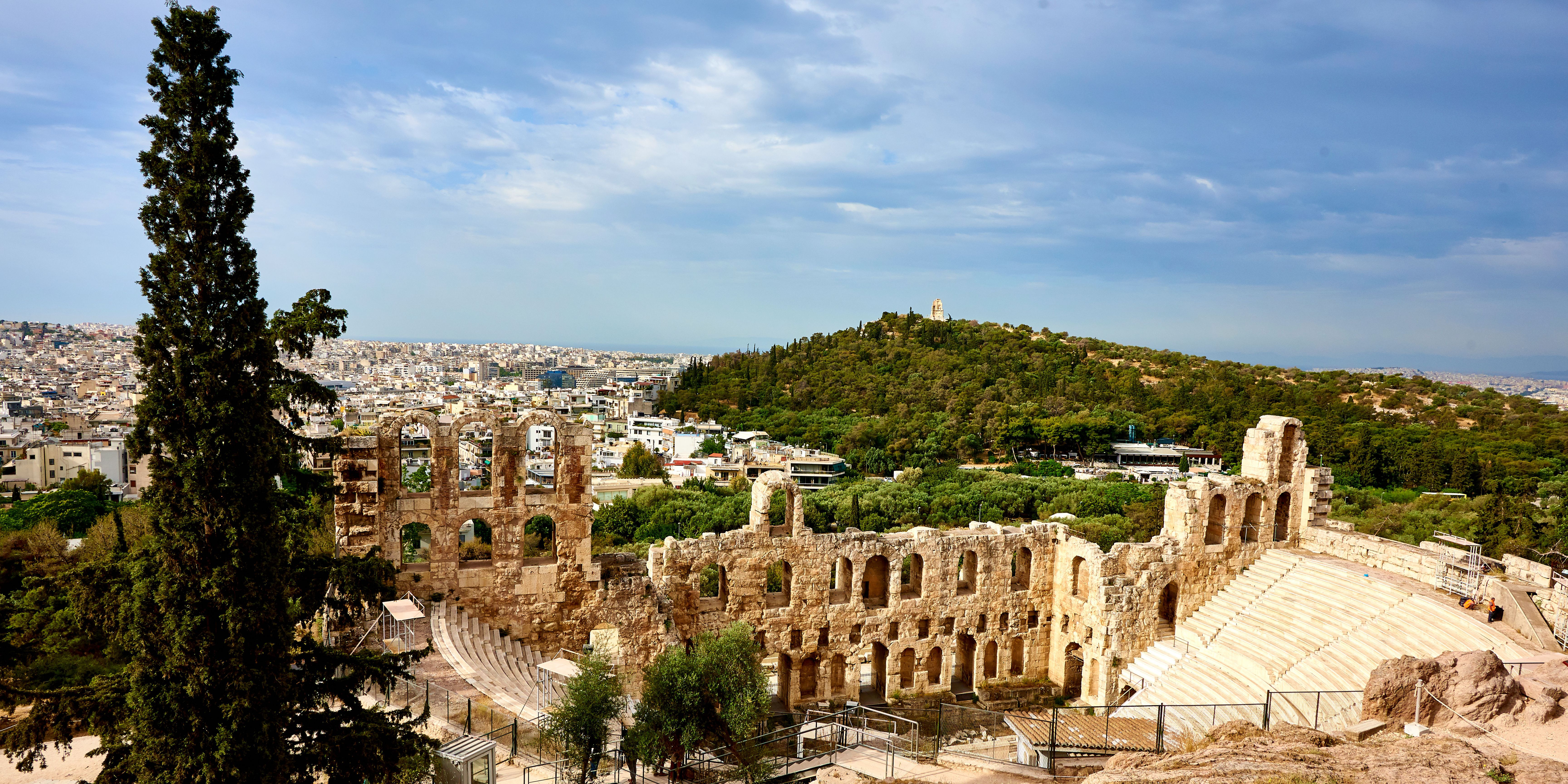 The Odeon of Herodes Atticus theater with the cityscape of Athens in the background.